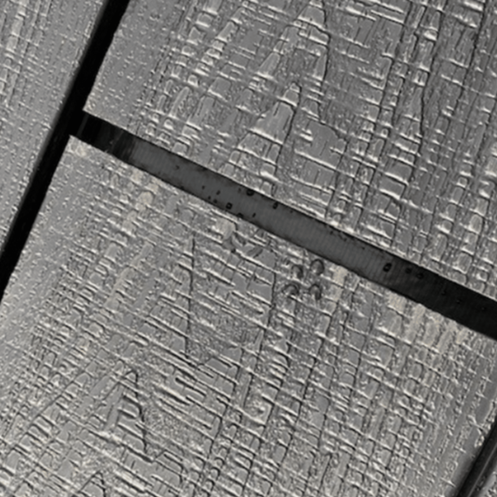 An image of composite boards being laid and the gap being covered by black decking tape.