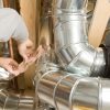 Placing Aluminium foil tape around metal sheeting.